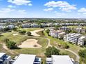 Scenic aerial view of condos nestled within a golf course community, showcasing the expansive green landscape at 1112 Sunset View Cir # 302, Reunion, FL 34747
