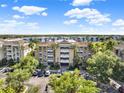 Beautifully landscaped condo building with ample parking surrounded by lush greenery and palm trees on a sunny day at 1112 Sunset View Cir # 302, Reunion, FL 34747