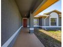 Welcoming front porch with a gray textured facade and a red front door for a pop of color at 1153 Perpignan Ct, Kissimmee, FL 34759