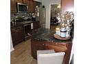 Stylish kitchen showcasing granite countertops, stainless steel appliances, and dark wood cabinetry at 1160 Rolling Acres Dr, Deland, FL 32720