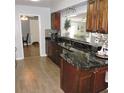 Modern kitchen with sleek dark countertops, wood floors, and a convenient pass-through to the living area at 1160 Rolling Acres Dr, Deland, FL 32720