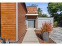 Modern house with wood paneling, corrugated metal accents, walkway and landscape at 11734 Lake Willis Dr, Orlando, FL 32821