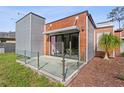 Modern architecture with glass railing patio, wood paneling, metal accents, and landscaping at 11734 Lake Willis Dr, Orlando, FL 32821