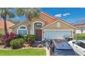 Inviting single-story home with red tile roof, two-car garage, and well-maintained front yard at 119 Hypolita Ave, Davenport, FL 33897
