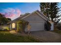 Charming single-Gathering home featuring a manicured front yard and a two-car garage at sunset at 121 Edgewater Cir, Sanford, FL 32773