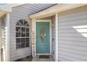 Stylish light blue front door with an decorative oval glass window, a 'Home' sign, and stone tile walkway at 121 Edgewater Cir, Sanford, FL 32773