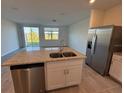 Well-lit kitchen featuring a center island, granite counters, stainless appliances, and an open-plan layout at 16464 Happy Eagle Dr, Clermont, FL 34714