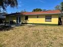 The house features a spacious backyard, concrete patio area and classic yellow siding at 235 Crabtree Ave, Orlando, FL 32835