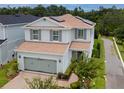 Two-story home featuring solar panels, a two-car garage, and well-maintained landscaping at 2683 Bobcat Chase Blvd, Oakland, FL 34787