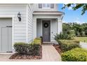 Inviting front entrance with a brick walkway, manicured bushes, and decorative wreath on a gray door at 2683 Bobcat Chase Blvd, Oakland, FL 34787