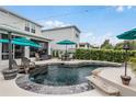 Backyard featuring a dark water pool, patio furniture, umbrella, and lush landscaping at 2683 Bobcat Chase Blvd, Oakland, FL 34787