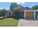 Charming single-story home with a manicured lawn, palm trees, and a two-car garage at 2979 Cool Breeze Cir, St Cloud, FL 34769