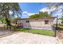 Charming single-story home featuring well-maintained yard, fenced perimeter, and inviting front entrance with wood stairs at 33506 Luana Ct, Leesburg, FL 34788
