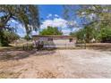 Charming single-story home featuring well-maintained yard, fenced perimeter, and inviting front entrance with wood stairs at 33506 Luana Ct, Leesburg, FL 34788