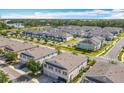 An aerial view showcases the beautiful townhouse community, lush landscaping, and surrounding lakes at 3449 Seneca Club Loop # B, Orlando, FL 32808