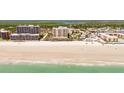 Expansive oceanfront condo building on a pristine beach, surrounded by lush greenery and neighborhood at 4071 S Atlantic Ave # 803, New Smyrna Beach, FL 32169