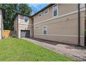 View of townhome exterior featuring green grass, a brick driveway, and attached garage at 41 E Spruce St, Orlando, FL 32804