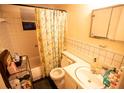 Bathroom features a tub with shower, tiled walls, and a vanity sink, providing essential amenities at 5505 Hernandes Dr # 108, Orlando, FL 32808