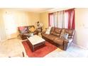 Cozy living room boasts tile flooring, comfortable leather seating, and a neutral color scheme at 5505 Hernandes Dr # 108, Orlando, FL 32808