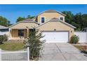 This home features an attached two-car garage, neutral paint, and an manicured front yard with a white picket fence at 602 Milan Dr, Kissimmee, FL 34758