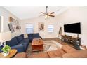 Cozy living room featuring a comfortable sofa, decorative shelving, and a mounted flat-screen television for entertainment at 659 N Endeavour Dr, Winter Springs, FL 32708