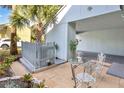 Private patio with charming metal bistro set, flowers, and palm tree at 7484 Canford Ct # 8, Winter Park, FL 32792