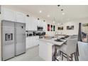 Modern kitchen with stainless steel appliances, granite countertops, and breakfast bar at 7587 Sunflower Cir, Kissimmee, FL 34747