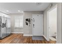 Welcoming foyer featuring hardwood floors, coat rack, and convenient access to a half-bath at 2652 Laser Ct, Orlando, FL 32826
