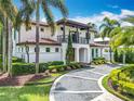 Beautiful two-story home with a tile roof, balcony, arched entry, and lush landscaping enhancing its curb appeal at 2614 Parkland Dr, Winter Park, FL 32789