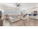 Open-concept living room with large sectional sofa and a ceiling fan, adjacent to the kitchen at 2747 Slash Way, St Cloud, FL 34771
