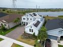 Two-story home with solar panels, paver driveway, landscaping, and beautiful views of the lake at 2926 Crest Wave Dr, Clermont, FL 34711