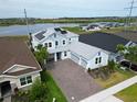 Beautiful two-story home with a paver driveway, solar panels, and well-manicured landscaping at 2926 Crest Wave Dr, Clermont, FL 34711