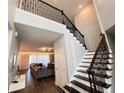 Grand foyer with hardwood floors, a soaring staircase with iron railings, and a view of the living room at 2926 Crest Wave Dr, Clermont, FL 34711