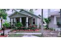Cozy single-story home featuring a quaint front yard with vibrant landscaping and a welcoming porch at 312 N Forest Ave, Orlando, FL 32803