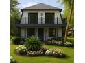 Beautiful two-story home featuring landscaped yard with colorful flowers, balcony, and modern design at 6850 Bass Hwy, St Cloud, FL 34771