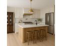 Modern kitchen featuring an island with seating, stainless steel appliances, and white cabinets at 6850 Bass Hwy, St Cloud, FL 34771