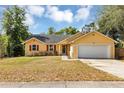 Charming yellow single-story home with a two-car garage, complemented by red shutters and a well-kept lawn at 6906 Colony Oaks Ln, Orlando, FL 32818