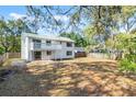 Spacious backyard with white balcony, a patio, a fence, and mature trees at 1220 Rolling Ln, Casselberry, FL 32707