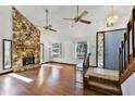Living room features hardwood flooring, a stone fireplace, a chandelier, and a stained-glass window at 1220 Rolling Ln, Casselberry, FL 32707