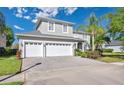 Exterior showcasing a three-car garage and patterned paver driveway at 13425 Paloma Dr, Orlando, FL 32837