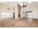 Open living room featuring high ceilings, a brick fireplace, tile flooring, and access to the backyard through sliding doors at 212 Hound Run Pl, Casselberry, FL 32707