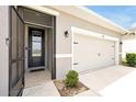 Welcoming front door with a storm door and a view of the two car garage at 260 Lake Smart Cir, Winter Haven, FL 33881