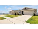 Beautiful home with a well-maintained lawn, a two-car garage, and a view of the water nearby at 260 Lake Smart Cir, Winter Haven, FL 33881