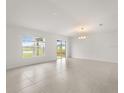 Spacious living room featuring tile flooring, a modern chandelier, and sliding glass doors to the backyard at 3823 Pronghorn Dr, St Cloud, FL 34772