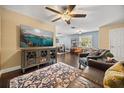 Well lit living room with hardwood floors, ceiling fan, leather furniture, and decorative rug at 5000 Ashford Falls Ln, Oviedo, FL 32765