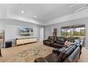 Spacious living room with plush leather seating, carpeted floors, and a sliding glass door with a view at 5981 Sierra Crown St, Mount Dora, FL 32757