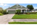 Charming single-story home featuring a well-manicured lawn, lush landscaping, and a welcoming front porch at 690 Cascading Creek Ln, Winter Garden, FL 34787
