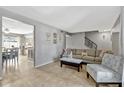 Inviting living room featuring tile floors, gray paint, and access to dining room and staircase at 1227 Carriage Ln, Orlando, FL 32807