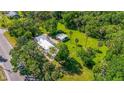 Expansive property featuring a home with a light metal roof, a separate structure, and lush greenery at 1405 Pioneer Trl, New Smyrna Beach, FL 32168