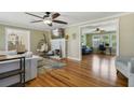 Open-concept living room with hardwood floors, fireplace, and views to office and dining at 1405 Pioneer Trl, New Smyrna Beach, FL 32168